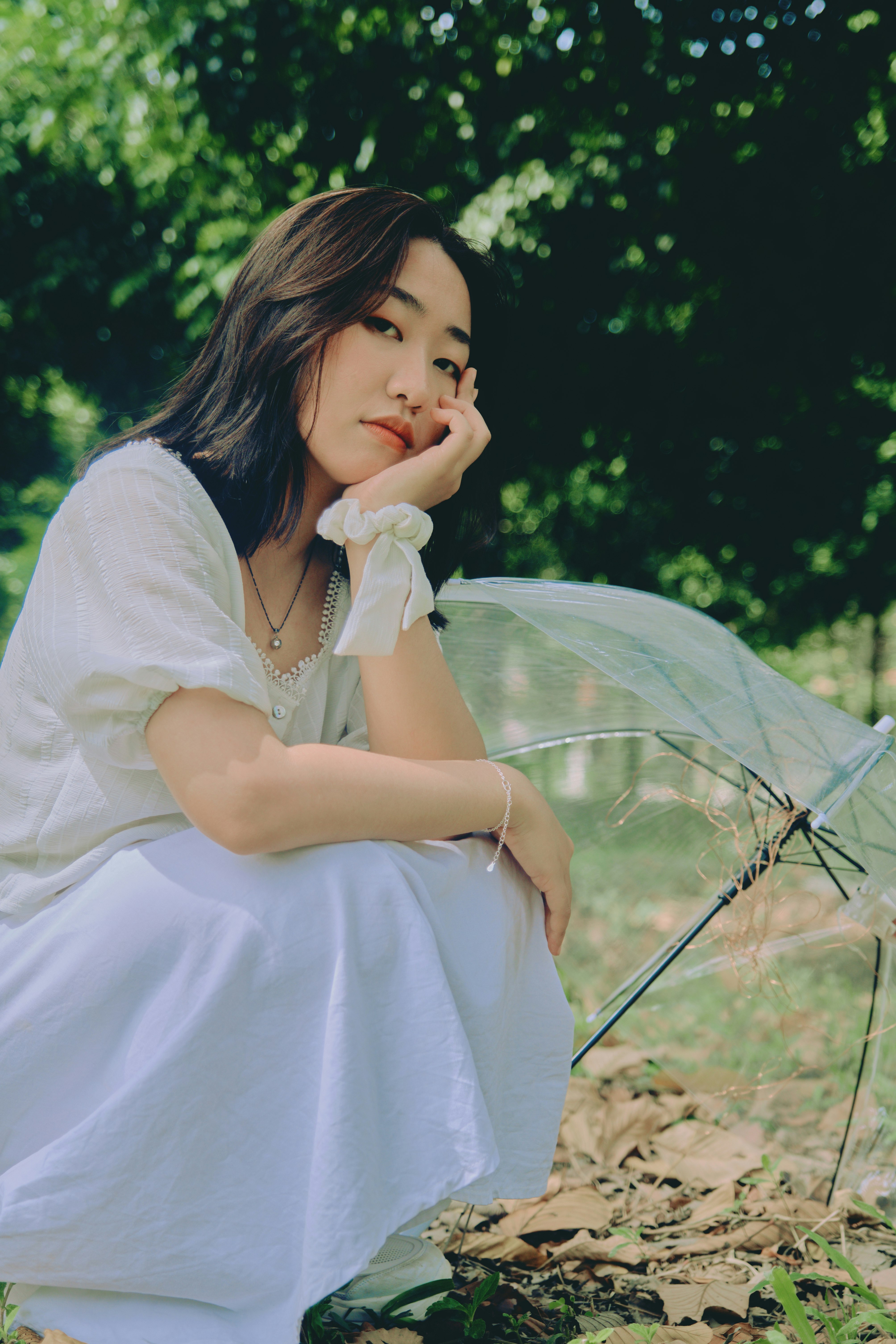 woman in white dress holding umbrella